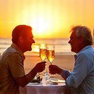 Couple toasting champagne at a sunset beach dinner