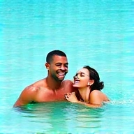 Newlywed couple laughing together in Caribbean waters